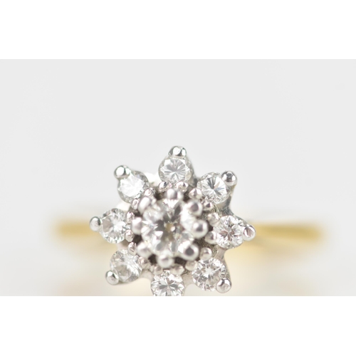 28 - A diamond 18ct yellow gold cluster daisy ring, the central brilliant cut diamond 3.5mm diameter, in ... 