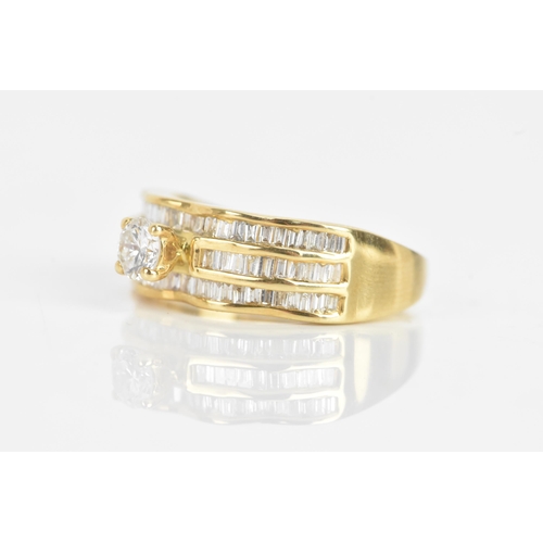 35 - A diamond and 18ct yellow gold ring set, the engagement ring having a brilliant cut diamond, calcula... 