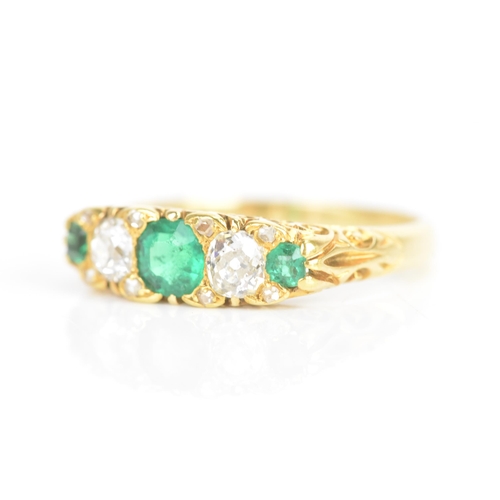 43 - A Victorian emerald and diamond 18ct yellow gold ring, having three emeralds flanking two old cut di... 