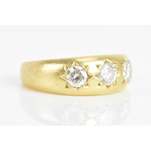 57 - A diamond 18ct yellow gold gypsy ring, having three brilliant cut diamonds in claw settings, the cen... 