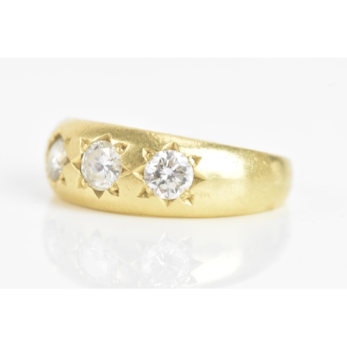 57 - A diamond 18ct yellow gold gypsy ring, having three brilliant cut diamonds in claw settings, the cen... 