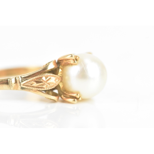 59 - A pearl 18ct yellow gold dress ring, the central pearl 7.8mm, in a four prong setting, with pierced ... 