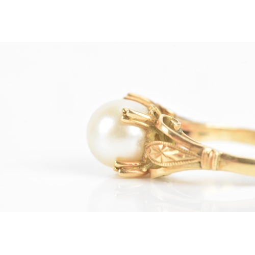 59 - A pearl 18ct yellow gold dress ring, the central pearl 7.8mm, in a four prong setting, with pierced ... 