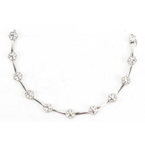 66 - A diamond 9ct white gold bracelet, the flexible links connected to flower ten flower heads, each ins... 