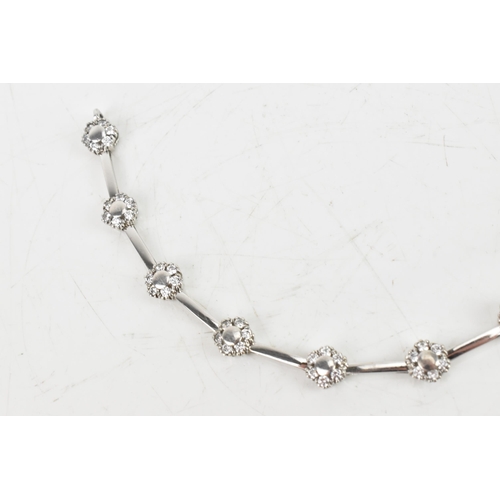 66 - A diamond 9ct white gold bracelet, the flexible links connected to flower ten flower heads, each ins... 