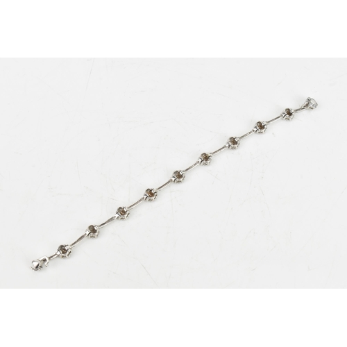 66 - A diamond 9ct white gold bracelet, the flexible links connected to flower ten flower heads, each ins... 