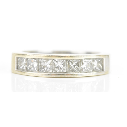 67 - A diamond 18ct white gold half eternity ring, having seven princess cut channel set diamonds, the ce... 