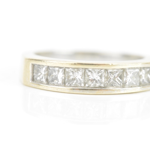 67 - A diamond 18ct white gold half eternity ring, having seven princess cut channel set diamonds, the ce... 