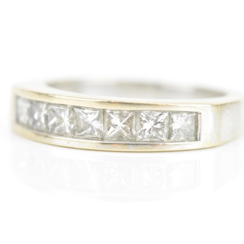 67 - A diamond 18ct white gold half eternity ring, having seven princess cut channel set diamonds, the ce... 