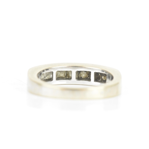 67 - A diamond 18ct white gold half eternity ring, having seven princess cut channel set diamonds, the ce... 