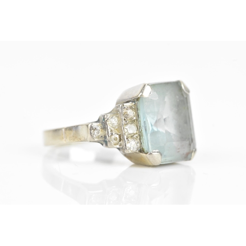 68 - An Art Deco aquamarine and diamond dress ring, the central aquamarine 11.6mm x 9.9mm , flanked by tw... 