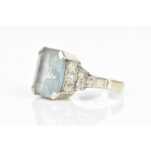 68 - An Art Deco aquamarine and diamond dress ring, the central aquamarine 11.6mm x 9.9mm , flanked by tw... 