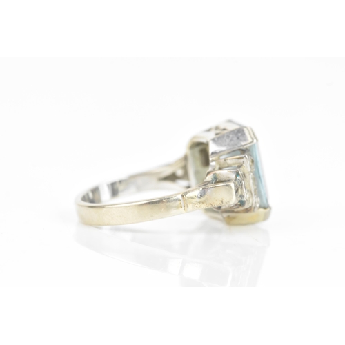 68 - An Art Deco aquamarine and diamond dress ring, the central aquamarine 11.6mm x 9.9mm , flanked by tw... 