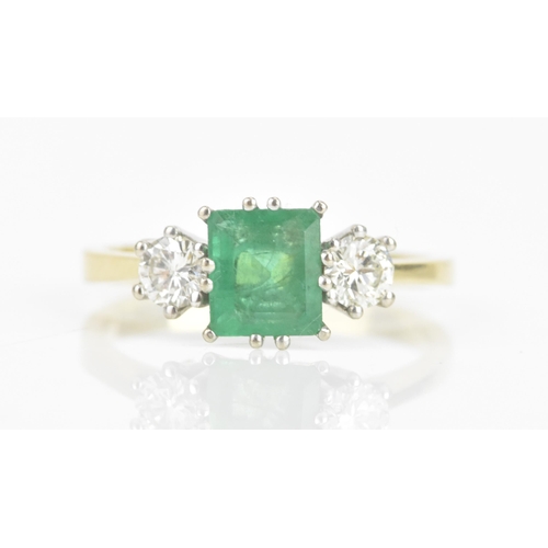 72 - An emerald and diamond 18ct yellow and white gold ring, the central emerald 6.3mm x 5.4mm, flanked b... 