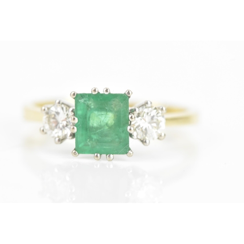 72 - An emerald and diamond 18ct yellow and white gold ring, the central emerald 6.3mm x 5.4mm, flanked b... 