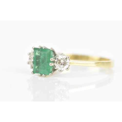 72 - An emerald and diamond 18ct yellow and white gold ring, the central emerald 6.3mm x 5.4mm, flanked b... 