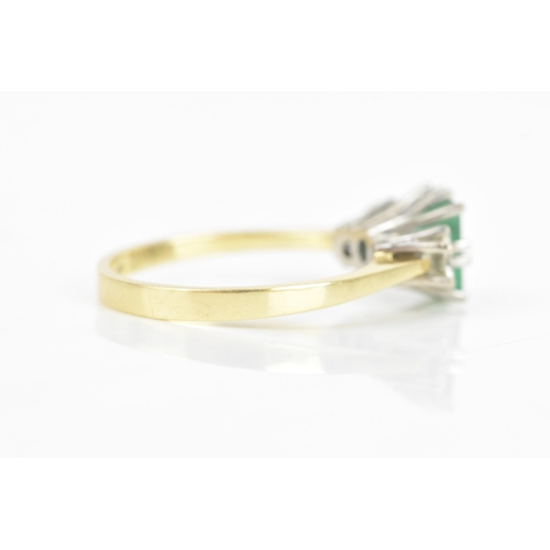 72 - An emerald and diamond 18ct yellow and white gold ring, the central emerald 6.3mm x 5.4mm, flanked b... 