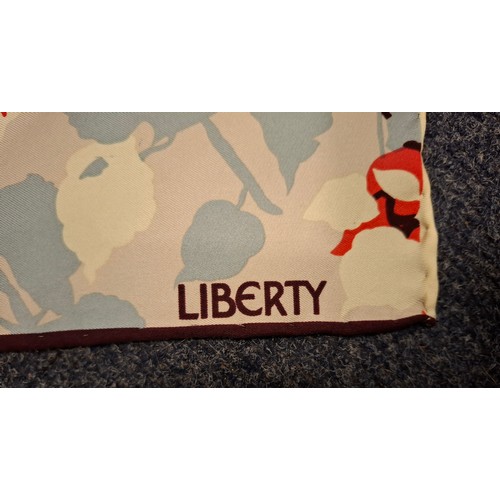 20 - Liberty- A 1980's un-used silk scarf with original tags having a cream, salmon pink, pale blue and b... 