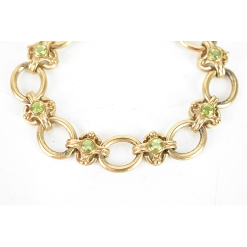 258 - A peridot 9ct gold chain link bracelet, having oval links and with eight faceted green peridots, eac... 