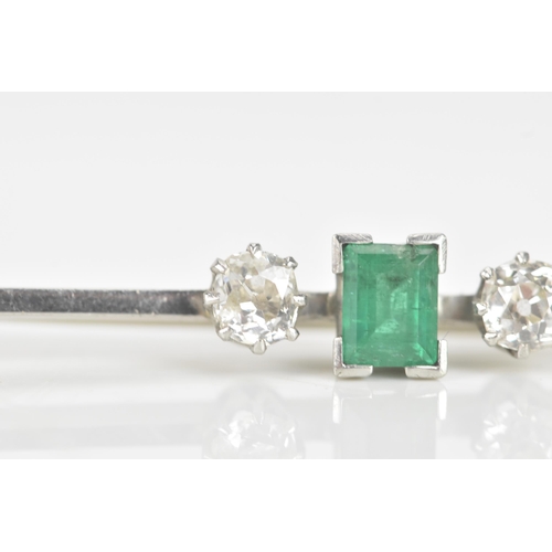 260 - An early 20th century emerald and diamond white metal bar brooch, the central emerald measuring 5.3m... 