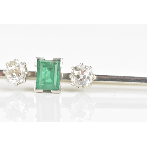 260 - An early 20th century emerald and diamond white metal bar brooch, the central emerald measuring 5.3m... 