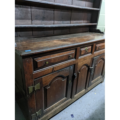 456 - An 18th century Georgian oak Welsh dresser, the plain top with three open shelves, the base with one... 