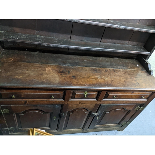 456 - An 18th century Georgian oak Welsh dresser, the plain top with three open shelves, the base with one... 