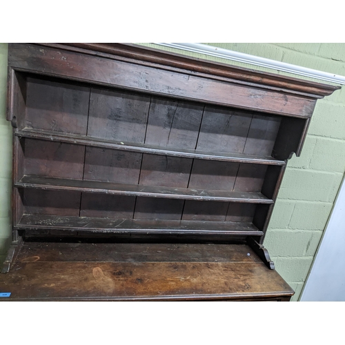 456 - An 18th century Georgian oak Welsh dresser, the plain top with three open shelves, the base with one... 