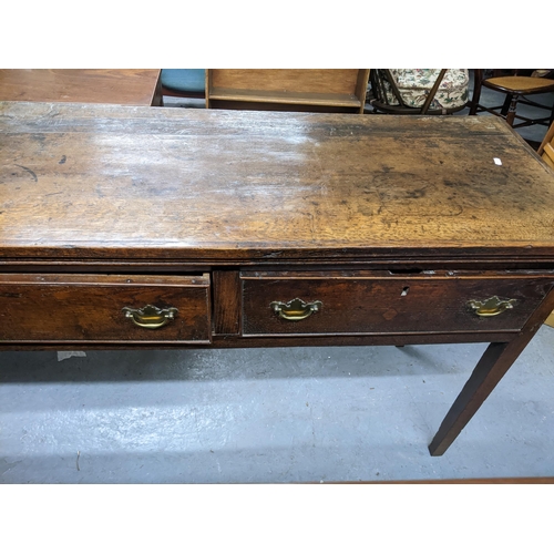 468 - A Georgian oak dresser base, three frieze drawers with brass swan neck handles on square tapering le... 