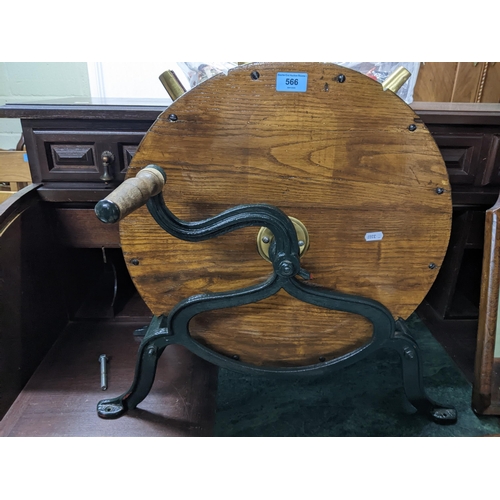 566 - A Victorian oak and cast iron knife sharpener, green painted base, with brass mounts stamped 