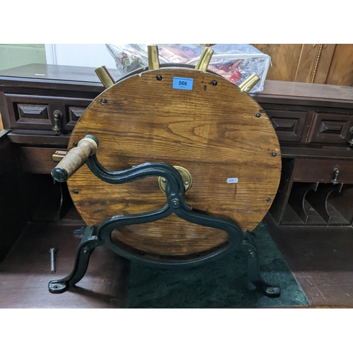 566 - A Victorian oak and cast iron knife sharpener, green painted base, with brass mounts stamped 