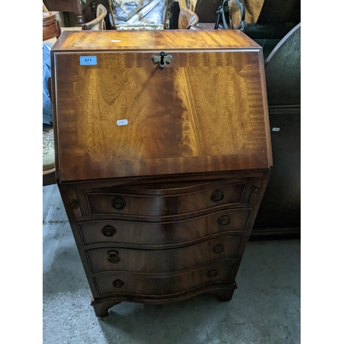 571 - A reproduction mahogany bureau of small proportions, serpentine fronted drawers and on bracket feet,... 