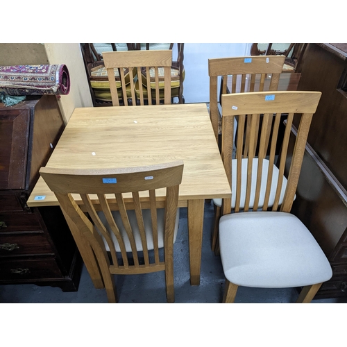 562 - A modern oak extending kitchen table 78cm x 80cm x 80cm when unextended, and four chairs Location: G... 