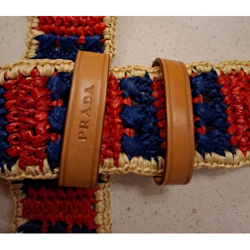 17 - Prada- A red, navy and cream straw belt with brown leather buckle and branded dust bag together with... 