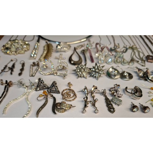 54 - A quantity of mainly modern silver costume jewellery to include earrings, fine chains and bangles. L... 