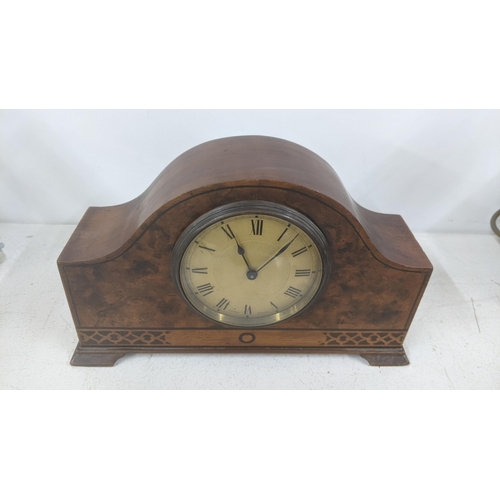 13 - An early 20th century marquetry inlaid arched top mantel clock having a mark 'Swiss Made' to the dia... 