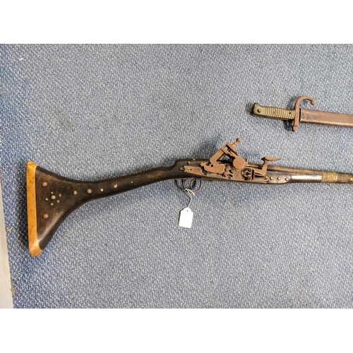 36 - A 19th century reproduction flintlock musket, along with a 19th century bayonet Location: LWF
If the... 