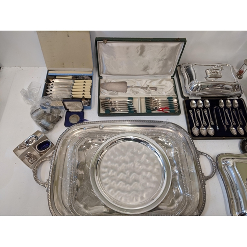 53 - A mixed lot of silver plate to include a boxed teaspoon, sugar tong set, a condiments set with liner... 