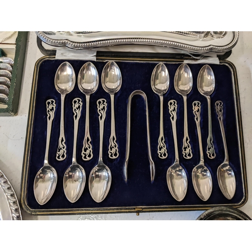 53 - A mixed lot of silver plate to include a boxed teaspoon, sugar tong set, a condiments set with liner... 