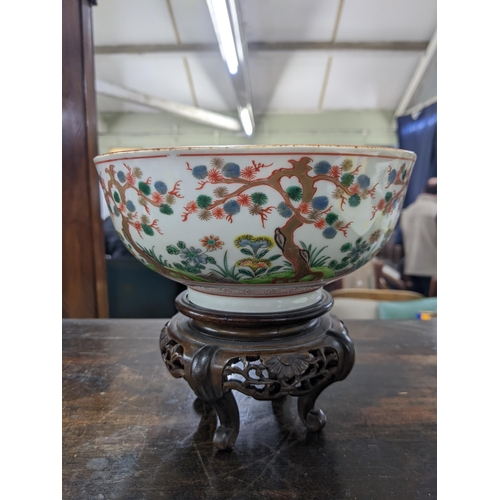 80 - A Japanese bowl and stand from the Meiji period decorated with Oriental plants and trees, 19cm dia, ... 