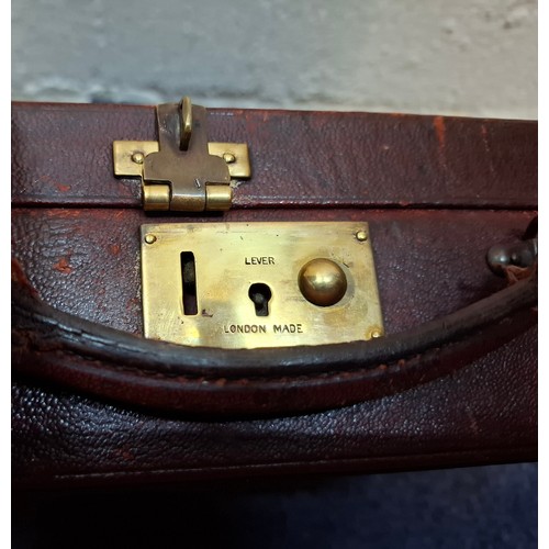 60 - A vintage 'London Made' burgundy leather jewellery box and contents to include 2 silver rings, an It... 