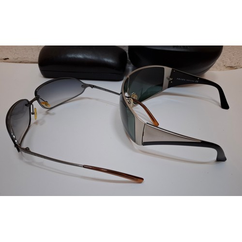 11 - Prada- 2 pairs of sunglasses, serial numbers 1AP-301 and 5AV-701 with black branded cases. Location:... 