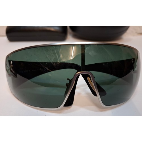 11 - Prada- 2 pairs of sunglasses, serial numbers 1AP-301 and 5AV-701 with black branded cases. Location:... 