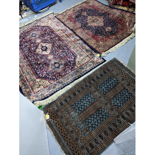 574 - Two Persian machine woven rugs with floral decoration on blue grounds, along with an Indian handwove... 