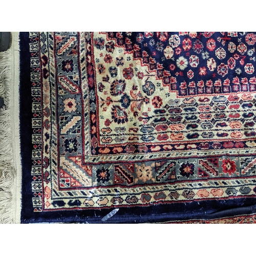 574 - Two Persian machine woven rugs with floral decoration on blue grounds, along with an Indian handwove... 