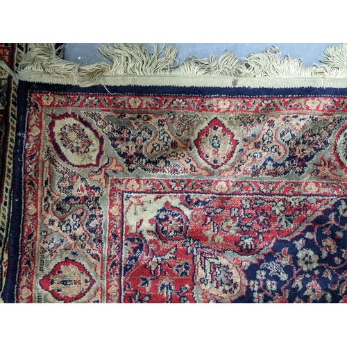 574 - Two Persian machine woven rugs with floral decoration on blue grounds, along with an Indian handwove... 