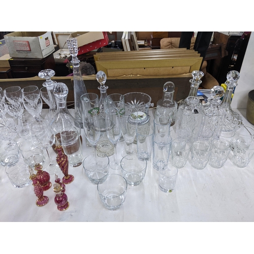 576 - A collection of glassware to include crystal cut decanters, wine glasses, a collection of blue art g... 