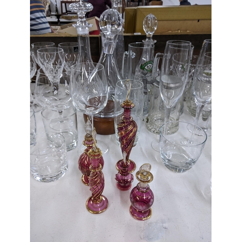 576 - A collection of glassware to include crystal cut decanters, wine glasses, a collection of blue art g... 