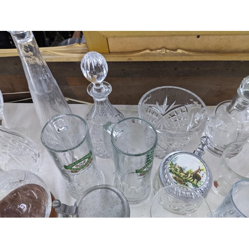 576 - A collection of glassware to include crystal cut decanters, wine glasses, a collection of blue art g... 