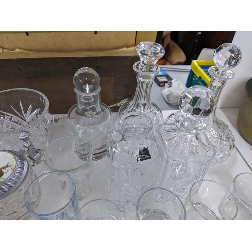 576 - A collection of glassware to include crystal cut decanters, wine glasses, a collection of blue art g... 